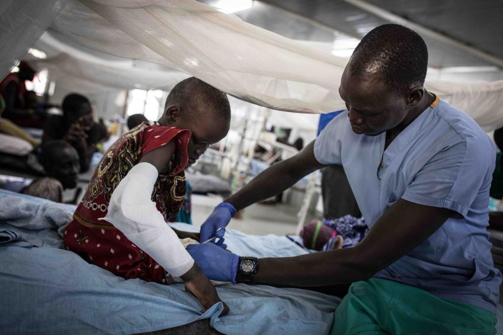 Medical personnel attends to a bandaged child, offering vital care and support, aided by a donation made with ETH.