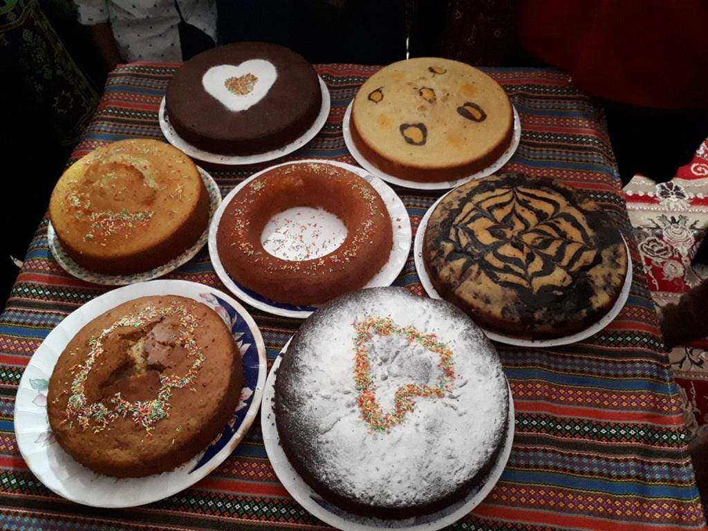 Assortment of cakes decorated with sprinkles and powdered sugar, some with heart designs, representing the joy of Eid al-Fitr celebrations and gifts after Ramadan fasts, with crypto donations via USDe facilitating support for the needy.