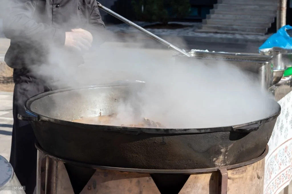 A chef prepares a large pot of food, with steam rising. Crypto donations support this charitable food distribution, likely via ETH.