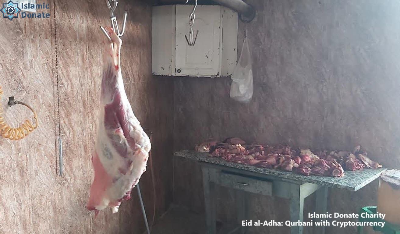 Qurbani meat distribution via crypto donation. A whole carcass hangs, with chopped meat on a table, symbolizing aid for the needy. Eid al-Adha with USDT.