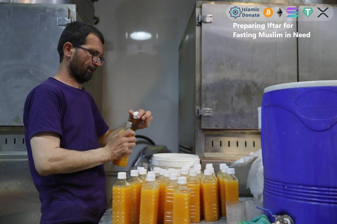 Male volunteer with t-shirt fills juice bottles for fasting Muslims in need support cryptocurrency charity.