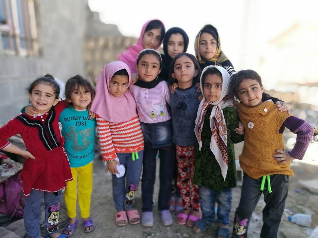 Muslim children smile while waiting for food aid and charity blessings. Give Iftar in Ramadan to refugee girls using DOGE.