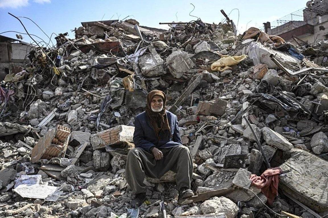 Elderly man sits amidst Gaza ruins as humanitarian aid via crypto aid supports survival efforts.