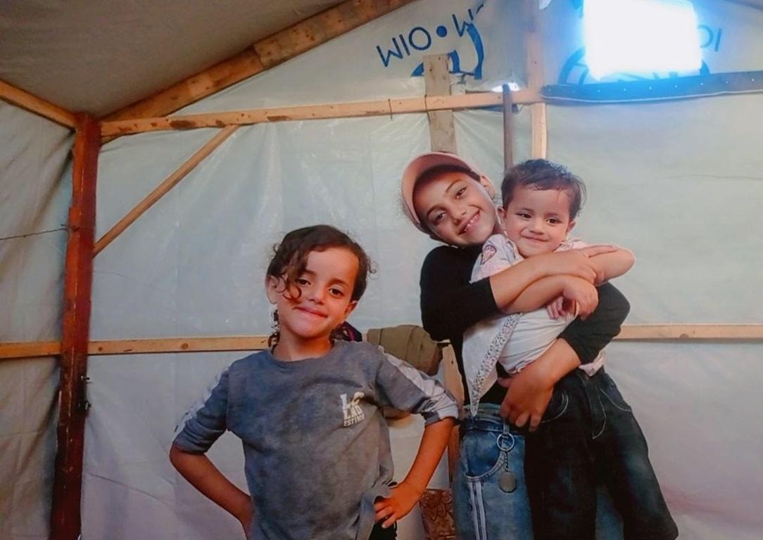 Displaced children inside a Gaza relief tent receive aid funded by USDT donations to ensure essential shelter and safety.