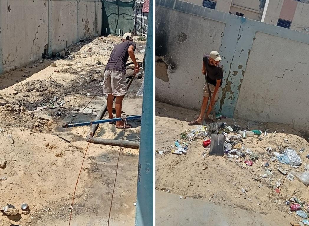 Man clearing rotting garbage from sand. Pax-gold donations fund hygiene at displacement camps.