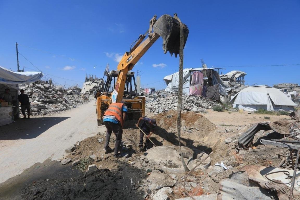 Gazan displacement camps sewage drainage via excavator. Use Tether-gold to fund hygiene kits and fight heat hazards and disease.