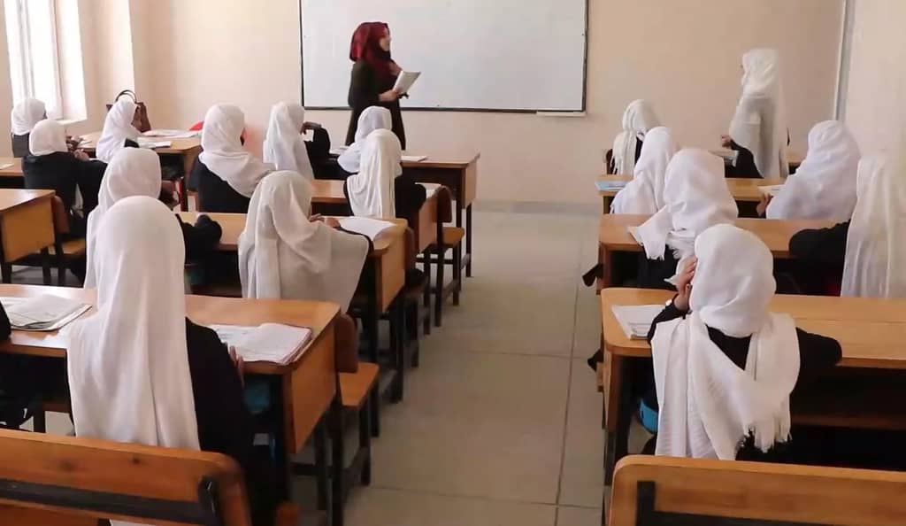 A teacher in a hijab leads a classroom of female students, many wearing hijabs, in a lesson. Donation via ETH.