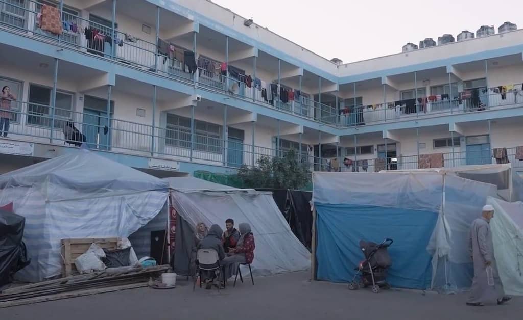 Aid to Gaza children receiving food and water delivered via crypto donations, facing new dangers as aid trucks are attacked; people live in makeshift shelters in Gaza.
