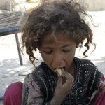 Child eating, implying aid is processed via USDT for humanitarian relief.