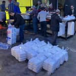 Volunteers in food distribution preparing meals for the needy during Ramadan, with crypto aided zakat support, likely using Bitcoin for donations to aid the Muslim Ummah.