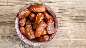A bowl of dates sits on a wooden surface, representing charitable giving with crypto support via USDT.