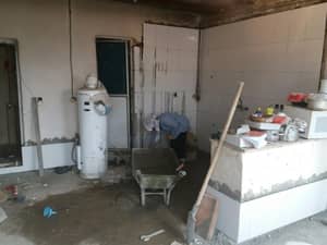 Construction or renovation in progress in a kitchen area with a person using a wheelbarrow and tools. Crypto zakat enables renovations like this, with donations via Stellar supporting essential projects.
