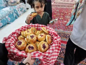 Child eating a pastry from a basket of baked goods. Zakat Al-Fitr donation supports vulnerable children's Eid celebrations, made possible with crypto donations like BTC.