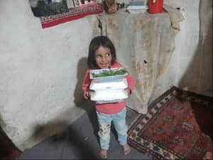 Child holding stack of food containers, anonymous crypto donations providing meals to hungry families via XRP.