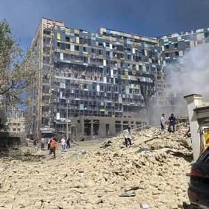 Devastated Okhmatdyt Children's Hospital in Kyiv after a missile strike, amidst rubble and smoke. People survey the damage. Crypto donations via ETH support urgent relief efforts for children, including medical supplies and shelter. Help Ukraine.