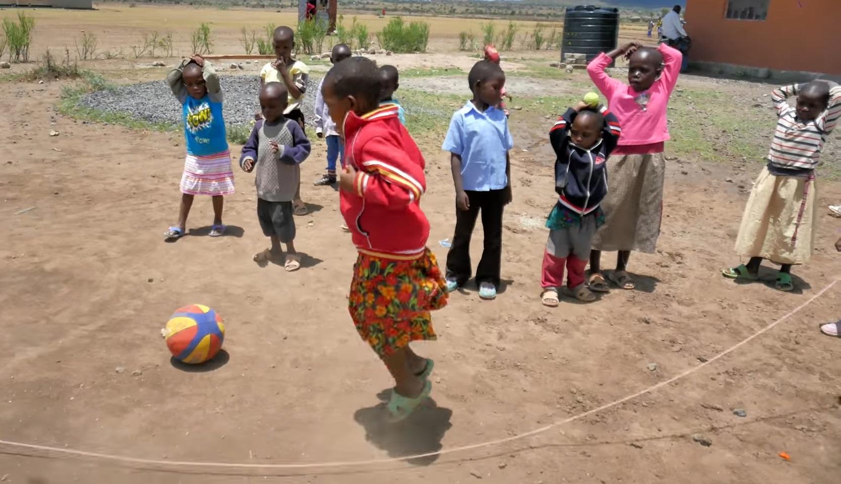 Children playing leapfrog outdoors with a ball, benefiting from crypto donations via USDT, supporting education for 49 orphans.