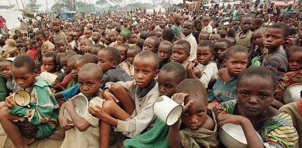 Children in Somalia holding bowls, awaiting aid for drought and hunger, supported by crypto donations via SOL.
