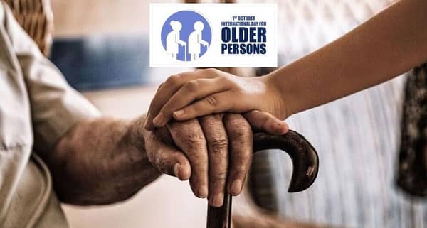 International Day of Older Persons, young person's hand resting on an elder's hand on a cane, acknowledging wisdom and experience, aided by crypto donations like BNB.