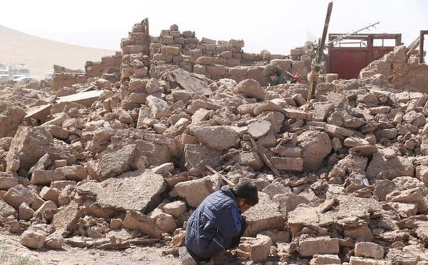 Afghanistan earthquake rubble with a child searching among the debris. Relief efforts aided by crypto donations like XRP enable rapid humanitarian support.