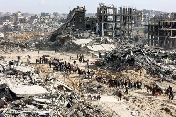 Devastation in Gaza with people sifting through rubble. Urgent aid for Palestine, including essential supplies and crypto donations via USDT.