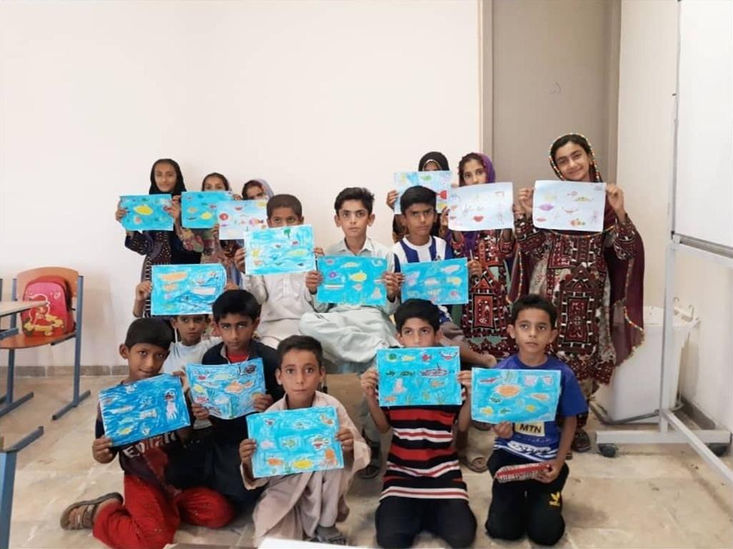 Children proudly display their artwork of marine life in a classroom, demonstrating the impact of educational programs supported by crypto donations, including ETH.