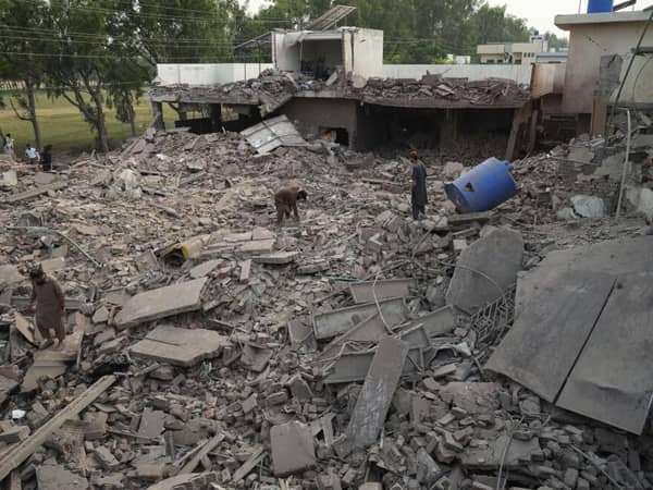 Devastated rubble of homes with people surveying the damage. Humanitarian aid for civilians in India-Pakistan conflict is urgently needed, with crypto donations like SOL making a direct impact.
