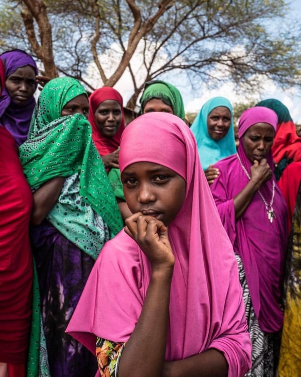 Women and girls in colorful hijabs, offering hope and dignity; this support is facilitated by crypto donations, including ETH.